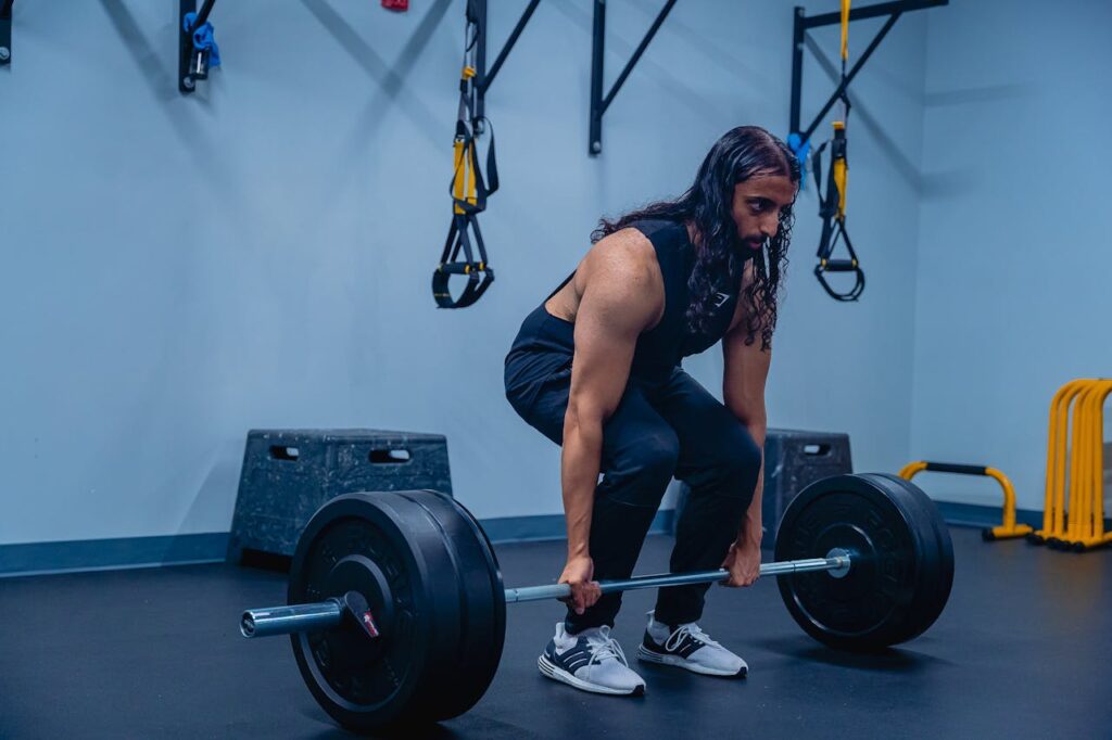 A man performing deadlifts in a gym, showcasing strength training and fitness routines.