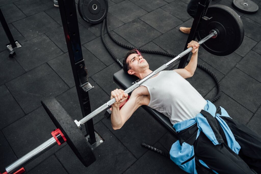 Adult male performing bench press in a Mexico City gym, showcasing strength training and fitness.